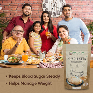 Family gathered around a table with a Khapli Atta package in the foreground.